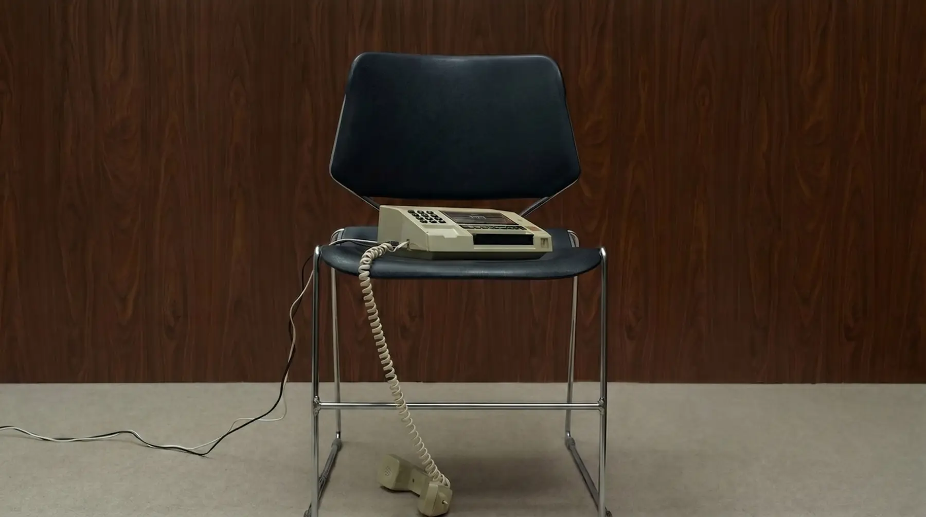 Cadeira com telefone em um ambiente corporativo.
